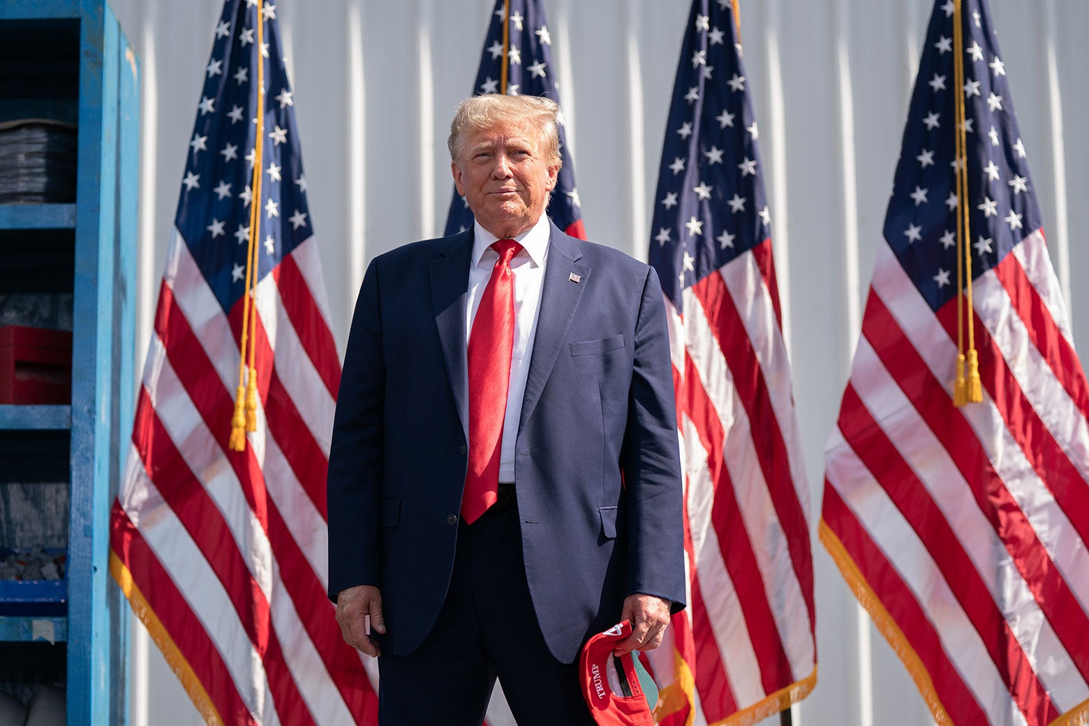 Trump smiling as he stands in a sea of flags.